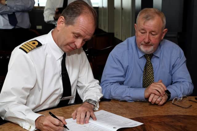 Commanding Officer, HMS Queen Elizabeth Captain Jerry Kid, signing the Certificate of Seaworthiness prior to the ship sailing from Rosyth