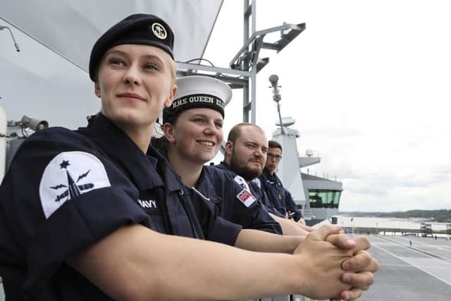 Proud members of the ship's company watch as the giant warship inches her way to sea for the first time. From left, Able Seaman (AB) Natasha Elford, AB Layton Toward and AB Richard Mead