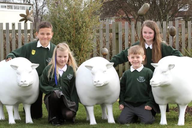 Pupils at Leesland C of E Junior School gather around one of the pre-decorated sheep. From left, the students are Logan Mitchell, Clancy Hamilton, Maisie McCormack and Oscar Kirkham