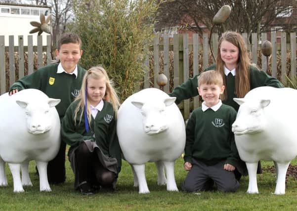 Pupils at Leesland C of E Junior School gather around one of the pre-decorated sheep. From left, the students are Logan Mitchell, Clancy Hamilton, Maisie McCormack and Oscar Kirkham