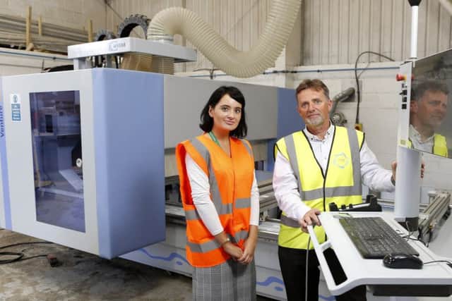 Lloyds Bank's Amey Green and Stevens Services Ltd MD Ian Stevens with new machinery that's set to boost company turnover