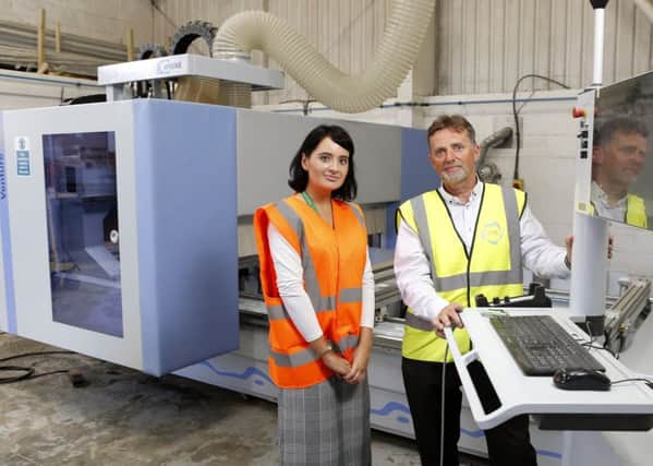 Lloyds Bank's Amey Green and Stevens Services Ltd MD Ian Stevens with new machinery that's set to boost company turnover