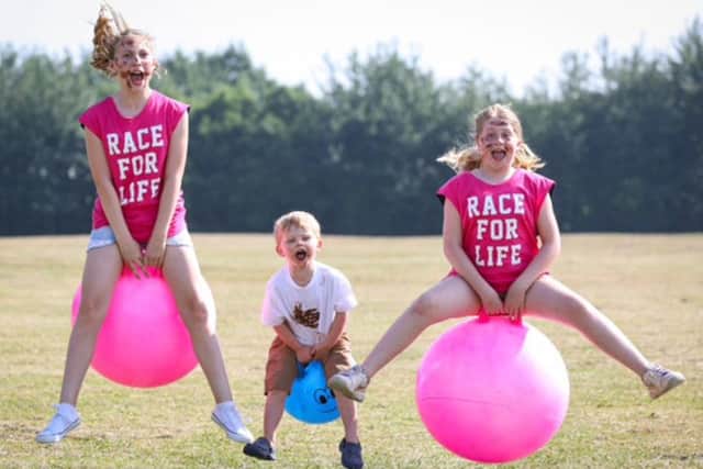 Isabella Alderton with her friends Austin Mayo and Clara Saban-Smith, testing out the space hoppers as they help launch Pretty Muddy Kids taking place in Portsmouth this weekend