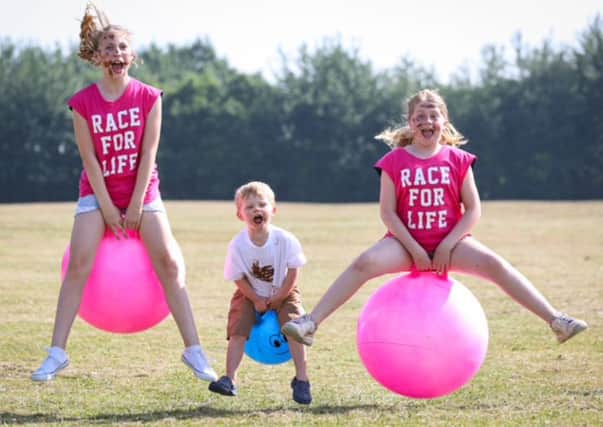Isabella Alderton with her friends Austin Mayo and Clara Saban-Smith, testing out the space hoppers as they help launch Pretty Muddy Kids taking place in Portsmouth this weekend