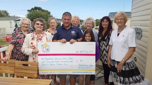 Members from Portsmouth Lodge of Duty No77 of the Order of Women Freemasons present a cheque to volunteers from Hannahs Holiday Home
