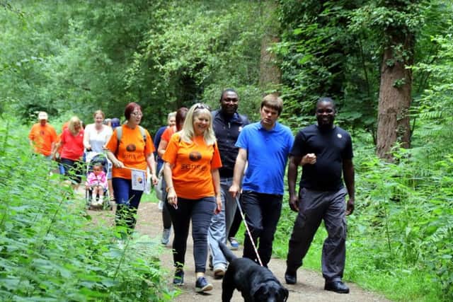 Adam Wood, front, with mother Gillian, left, and support worker Ade Bello and dog Jasper