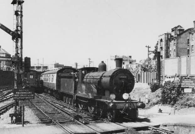 When Britain had a navy there was a great need to move its men from port to port and on a summer day in July 1959 the Portsmouth & Southsea to Plymouth express can be seen approaching Fratton station where it would pass through non-stop.
A loud warning bell located on the fence to the front of the locomotive would sound to warn anyone wanting to cross the track by footboards at the end of the station and in between the platforms.
Although the sign states passengers must use the bridge, women with prams would be escorted by a member of staff  across the line at this point.
A Hampshire  diesel unit has just left the platform on the down side  and the signalman has yet to put the starting signal back to stop.
Above the  blood and custard liveried first carriage can be seen the Guards clothing factory  south of Fratton Bridge.