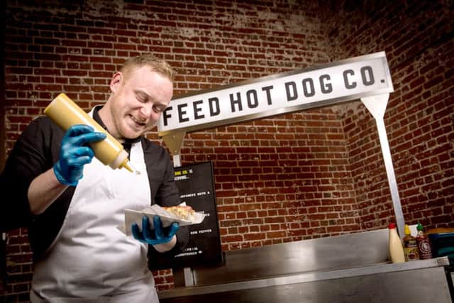 Pete Hunthe owner of Feed Hot Dog Co, sauces up one of his hot dogs                                                               Picture: Sean Ebsworth Barnes