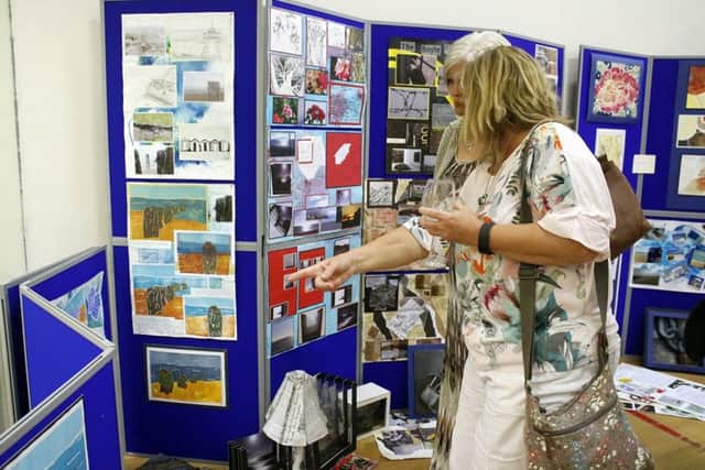 Impressed visitors to the art exhibition pick out their favourite pieces