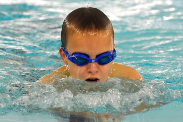 Dominic Redpath in action and, inset, with four of his many swimming medals