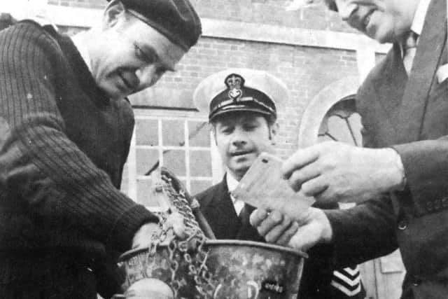 jpns-15-07-17 retro july 2017bucket - Examining the bucket after it had been presented to the Victory Museum, Portsmouth, are (left to right) Admiral Sir Terence Lewin, Chief PO Bill Rosewell, and Captain AJ Pack, the director of Portsmouth RN Museum