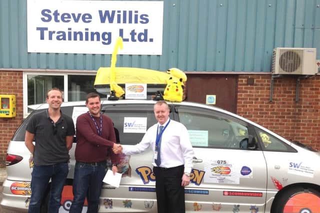 Managing Director Steve Willis presents James and Matthew with his donation