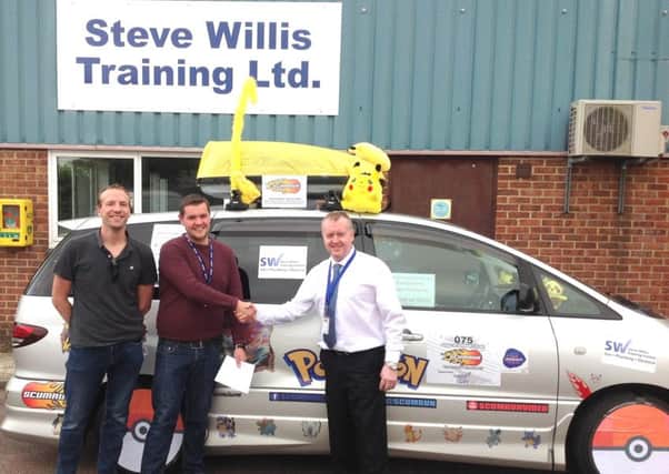 Managing Director Steve Willis presents James and Matthew with his donation