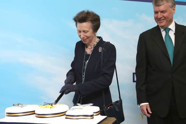 The princess cuts the celebration cake, watched by Sean Woodward