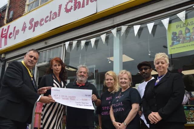 Cllr David Fuller, left, presents Keith Shaw, centre, with the Â£30,000 cheque