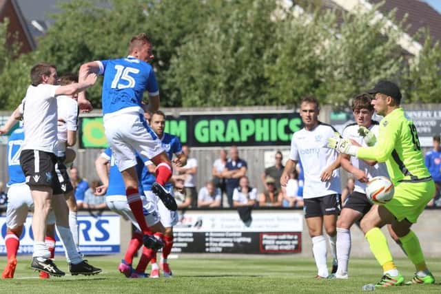 Tom Davies scores a header in Pompey's pre-season game at Salisbury. Picture: Habibur Rahman