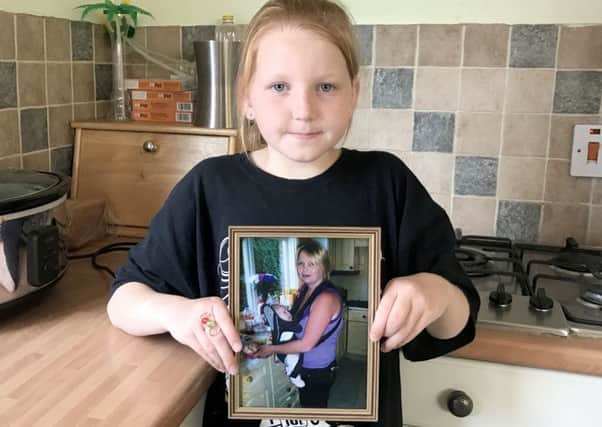 Grace Hutton, nine, from Cosham, is having her head shaved in memory of her mum Paula (in the picture frame)