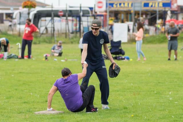 An American sailor helps up his opponent during the friendly softball game

Picture by Vernon Nash