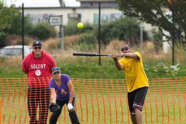 An American sailor batting in the softball match 

Picture by Vernon Nash