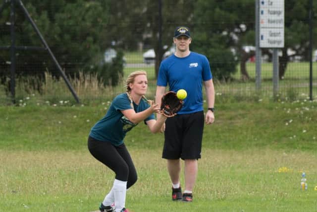 A British player catches at first base 

Picture by Vernon Nash