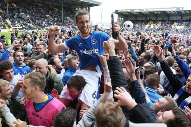Christian Burgess celebrates Pompey's promotion with fans. Picture: Joe Pepler