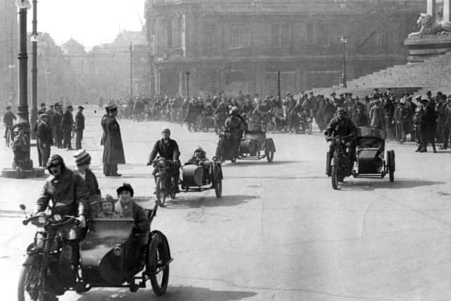 On a sunny Sunday, motorcycles and sidecars parade through Guildhall Square, Portsmouth.
