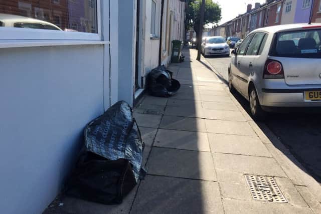 Black council-provided canvas sacks along Newcome Road