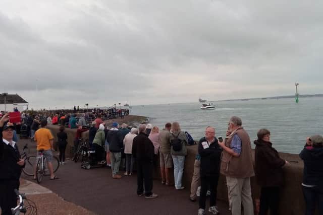 People line Southsea seafront as they wait for HMS Queen Elizabeth, which can be seen in the background