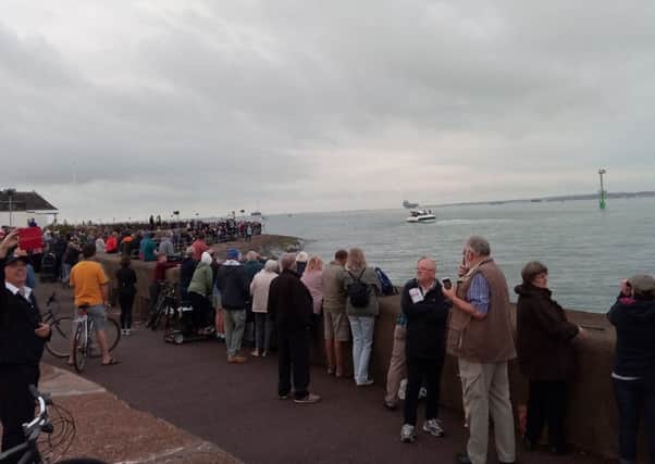 People line Southsea seafront as they wait for HMS Queen Elizabeth, which can be seen in the background