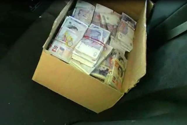 Still from a video shown to jurors at Portsmouth Crown Court of cash allegedly found in the back of Marcel Daci's Mercedes
