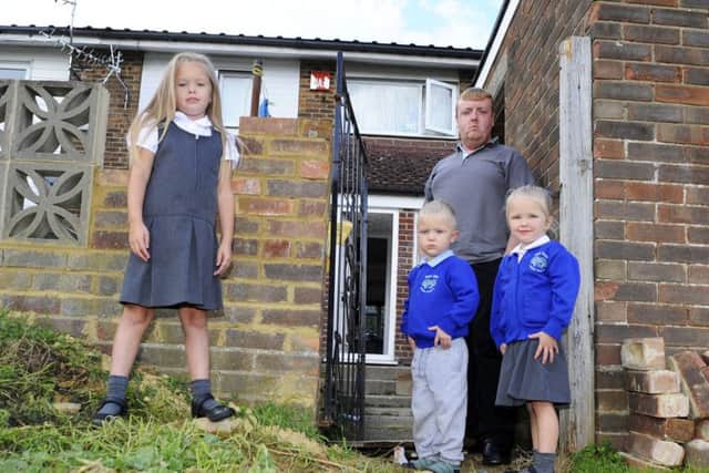 Maddison Betteridge, six, with Luke Betteridge, 25 and three-year-old twins Reggie-Lucas Betteridge and Ruby-Lou Betteridge in their rear garden gateway where the landlord has just started to re-build the fallen pillar. Picture: Malcolm Wells