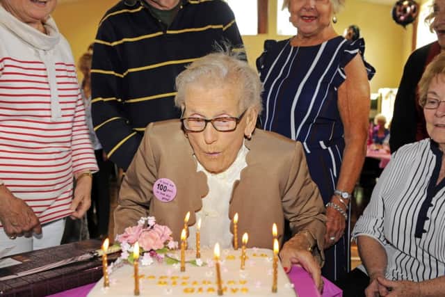 Gladys Grimstead blows out the candles on her 100th birthday cake. Picture: Malcolm Wells (170914)