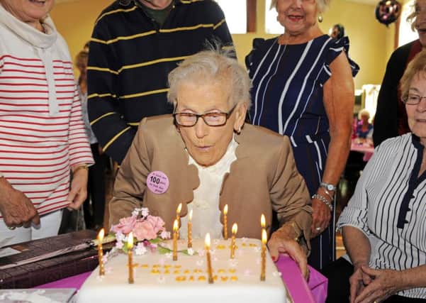 Gladys Grimstead blows out the candles on her 100th birthday cake. Picture: Malcolm Wells (170914)