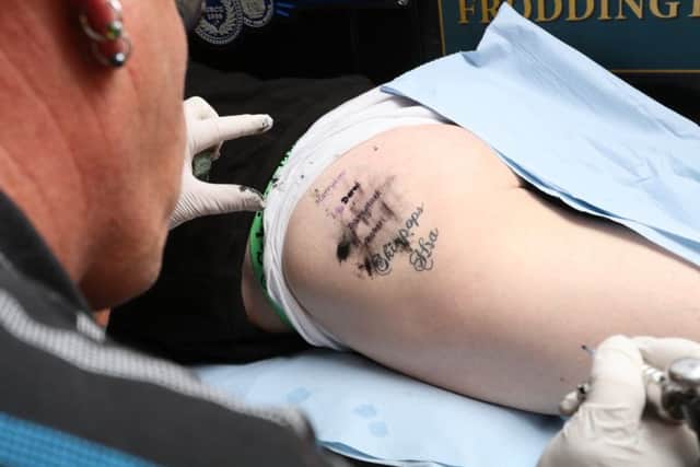 A tattooist adds names to Keith's bottom  Pictures: Habibur Rahman