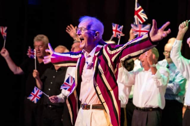 Keith Fossey, the compere for the evening, rallies the audience during Gosport Men's Shed Gang Show