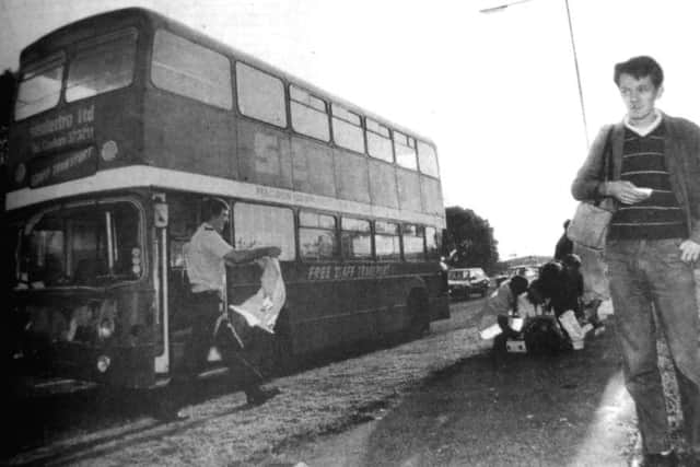 An ambulanceman moves in to assist the injured after a bus crash. Stephen Hayden, right with injuries to his face, waits for the ambulance