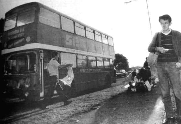 An ambulanceman moves in to assist the injured after a bus crash. Stephen Hayden, right with injuries to his face, waits for the ambulance