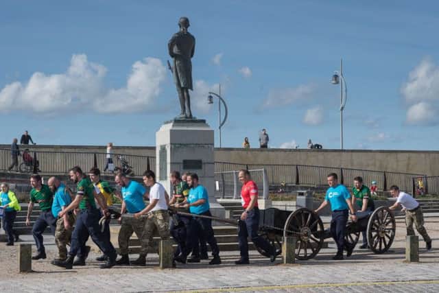 The team passes the Nelson statue in Old Portsmouth. Picture: Keith Woodland (171022-0023)
