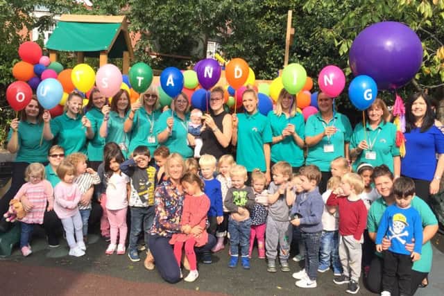 Lucy Whitehead, the owner of Rainbow Corner with children and staff after the Outstanding verdict from Ofsted