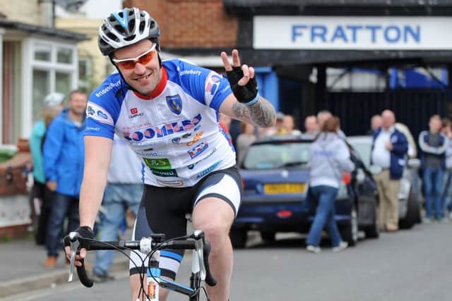 Carl Paddon waves goodbye as he leaves Fratton Park for the 2014 Ride2Bury cycle challenge Picture: Sarah Standing (141216-5002)