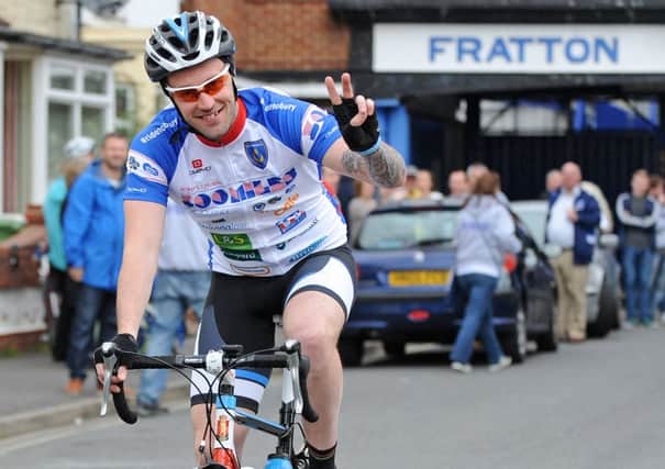 Carl Paddon waves goodbye as he leaves Fratton Park for the 2014 Ride2Bury cycle challenge Picture: Sarah Standing (141216-5002)