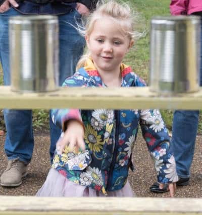 Ruby Stanbridge, three, tries to knock down cans to win a prize. Picture Credit: Keith Woodland PPP-170930-203507006