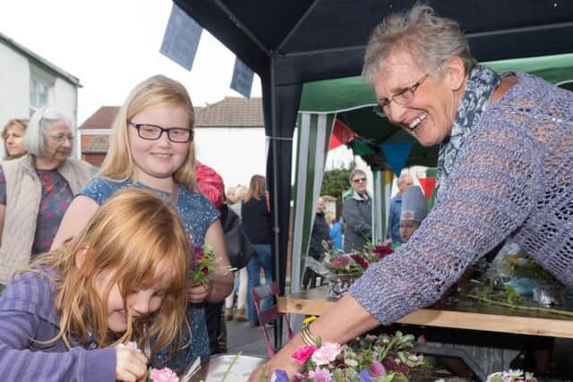 Mollie, six, and Amalia Lyon, eight, make posies with Anne-Maree Dicker of the Gosport Floral Art Club raising money for GAFIRS. Picture Credit: Keith Woodland PPP-170930-203542006