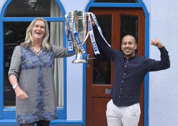 Clare Martin, director of Pompey in the Community, and Faz Ahmed of The Akash holding the League Two trophy
