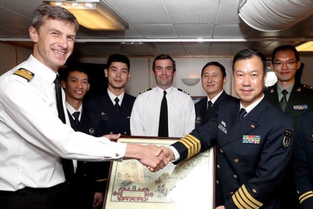 Chinese guests recieve a gift from Commodore Peter James Sparkes BSC(HONS), Royal Navy Commander, Portsmouth Flotilla,  on behalf of the Royal Navy.