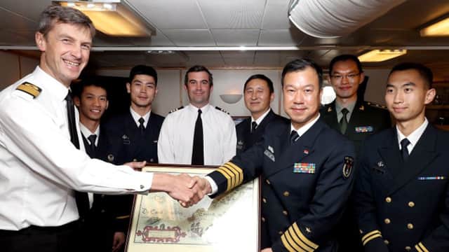 Chinese guests recieve a gift from Commodore Peter James Sparkes BSC(HONS), Royal Navy Commander, Portsmouth Flotilla,  on behalf of the Royal Navy.