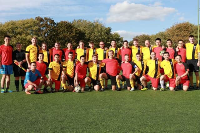 Both the Royal Navy and Chinese Navy teams together after their football match. 

The event was held at HMS Temeraire