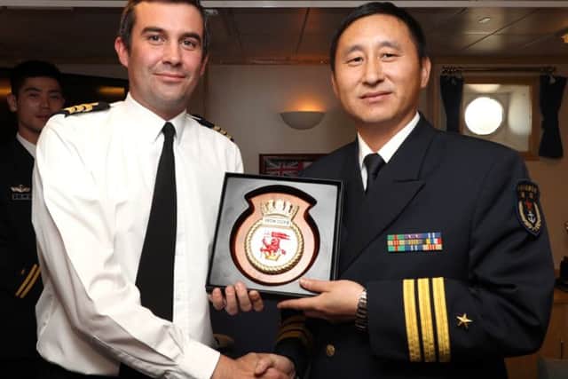 Commanding Officer of HMS Iron Duke, Commander Steven Banfield, MBE, presenting a gift to Chinese Captain HongWei Zhang