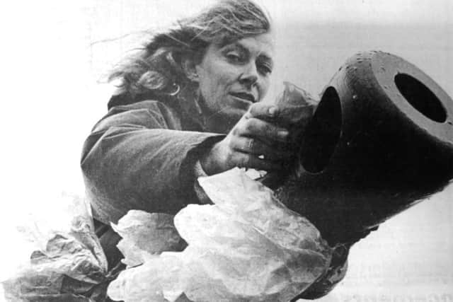 A peace woman helps decorate the tank outsice the D-Day Museum