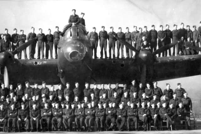 Airmen and officers pose for the camera on and around a Lancaster bomber.